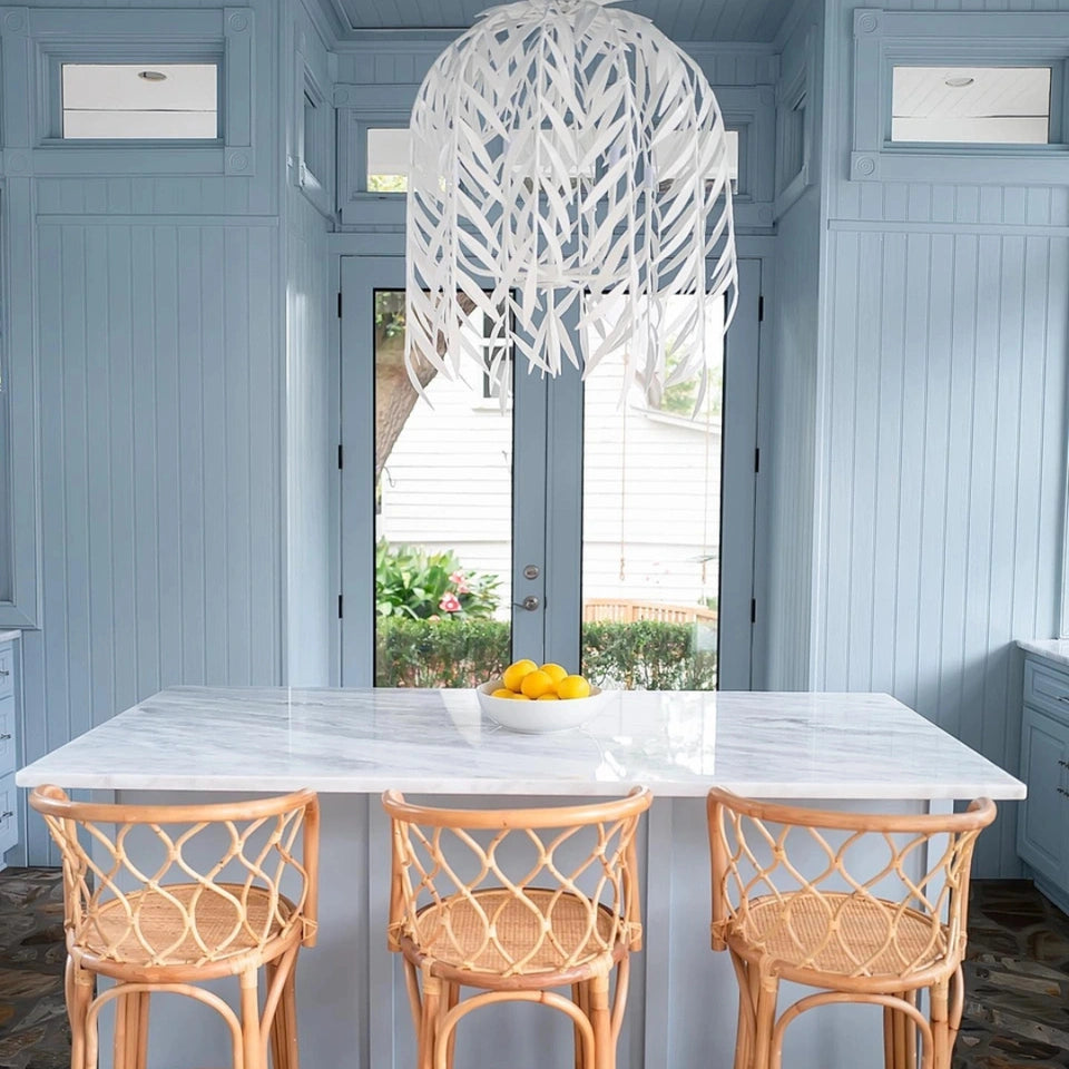 Stray Dog Designs Willow Chandelier hanging over a marble counter top with bamboo bar chairs in a kitchen bathed in a muted light blue paint color.
Gray Benko Home, Interior Design Inspiration, luxury lighting, coastal aesthetic, kitchen inspiration