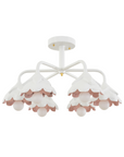 A white flush mount ceiling light fixture with a floral design, featuring pink inner cups and gold accents.