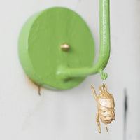 James wall sconce with dangling gold bug, green papier mache and iron