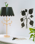 gold iron lamp with branches, black scalloped shade and green bird