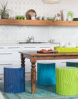 stump stools in a variety of greens and blues around a kitchen table